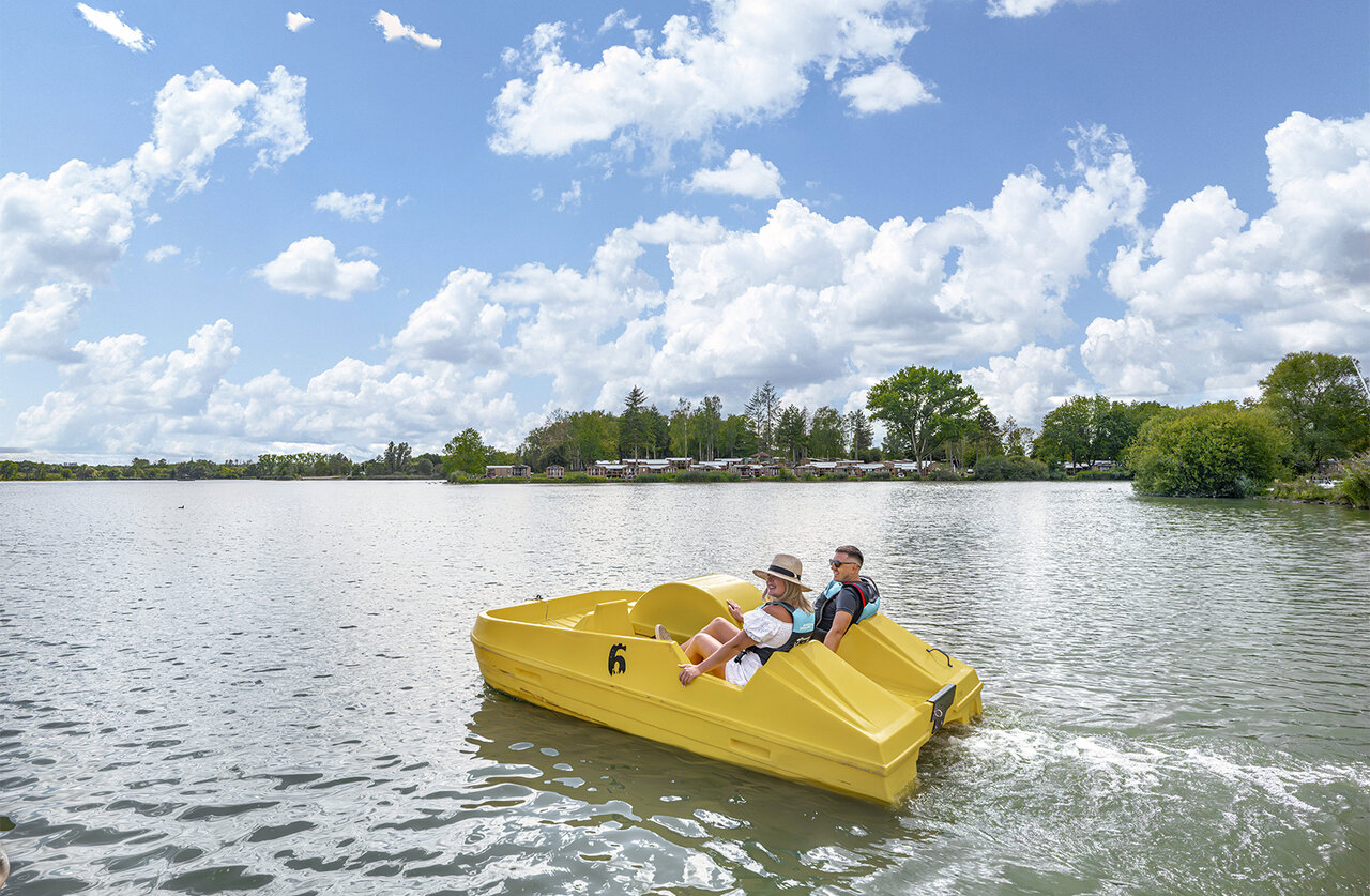 Couple on pedal boat on lake, camping CLICOCHIC Etang de la Mutche.