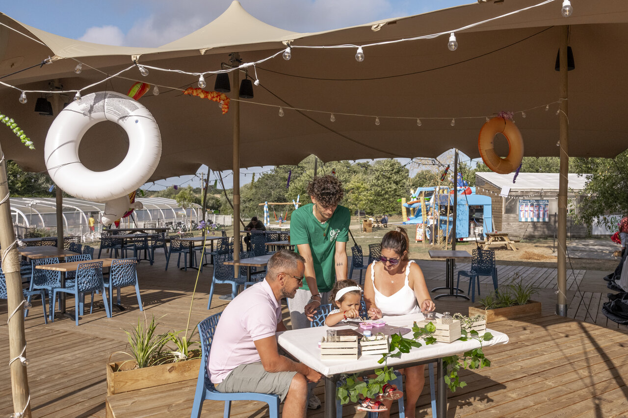 Outdoor restaurant, family, playground, swimming pool at CLICOCHIC Etoile de Mer campsite in Asserac (44).
