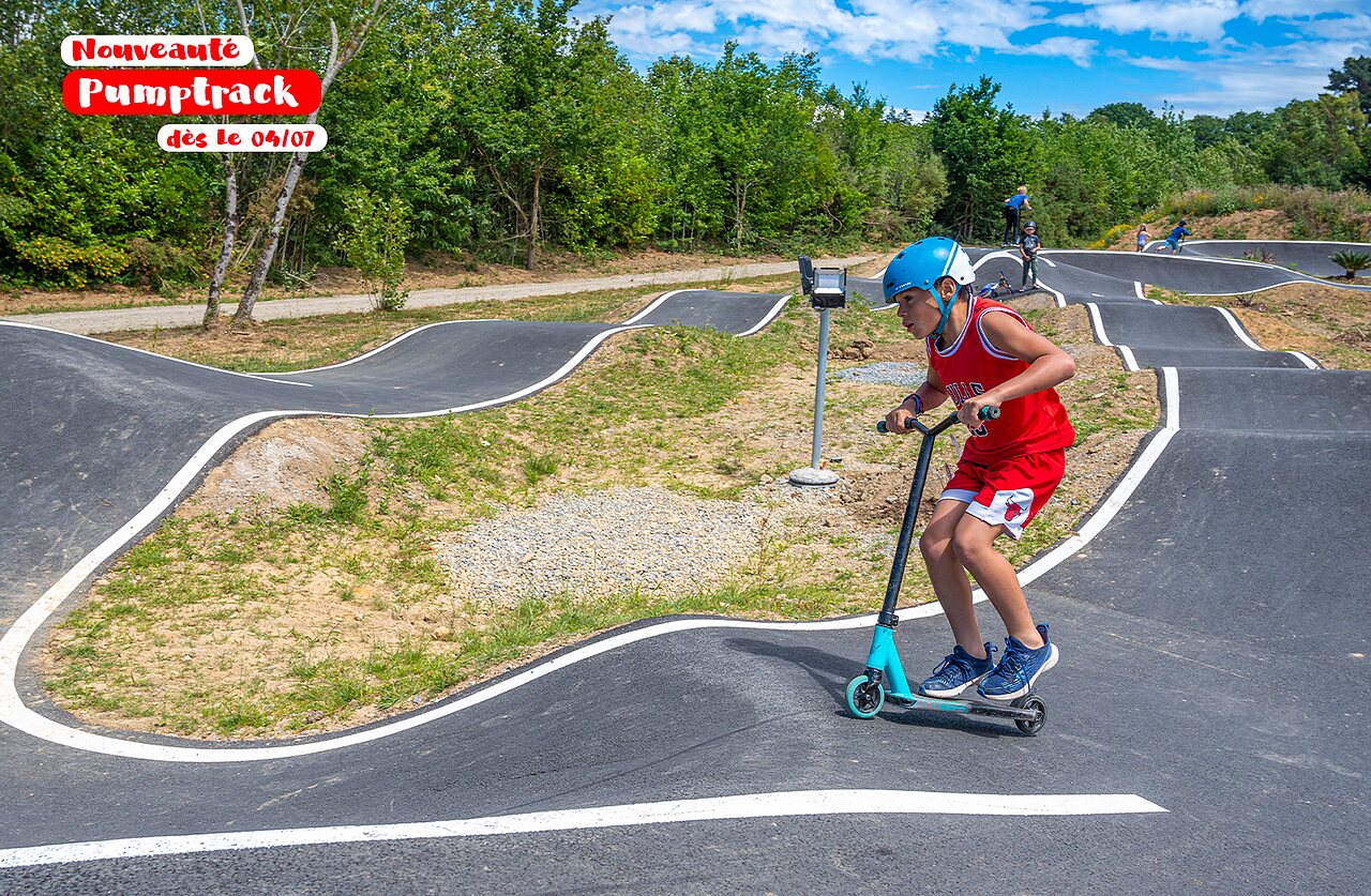 Child on scooter on the modern pumptrack at CAPFUN Europing campsite in Tarquinia (01).