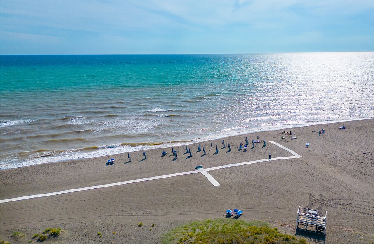 Sandy beach, parasols and Mediterranean Sea at CAPFUN Europing campsite in Tarquinia (01).
