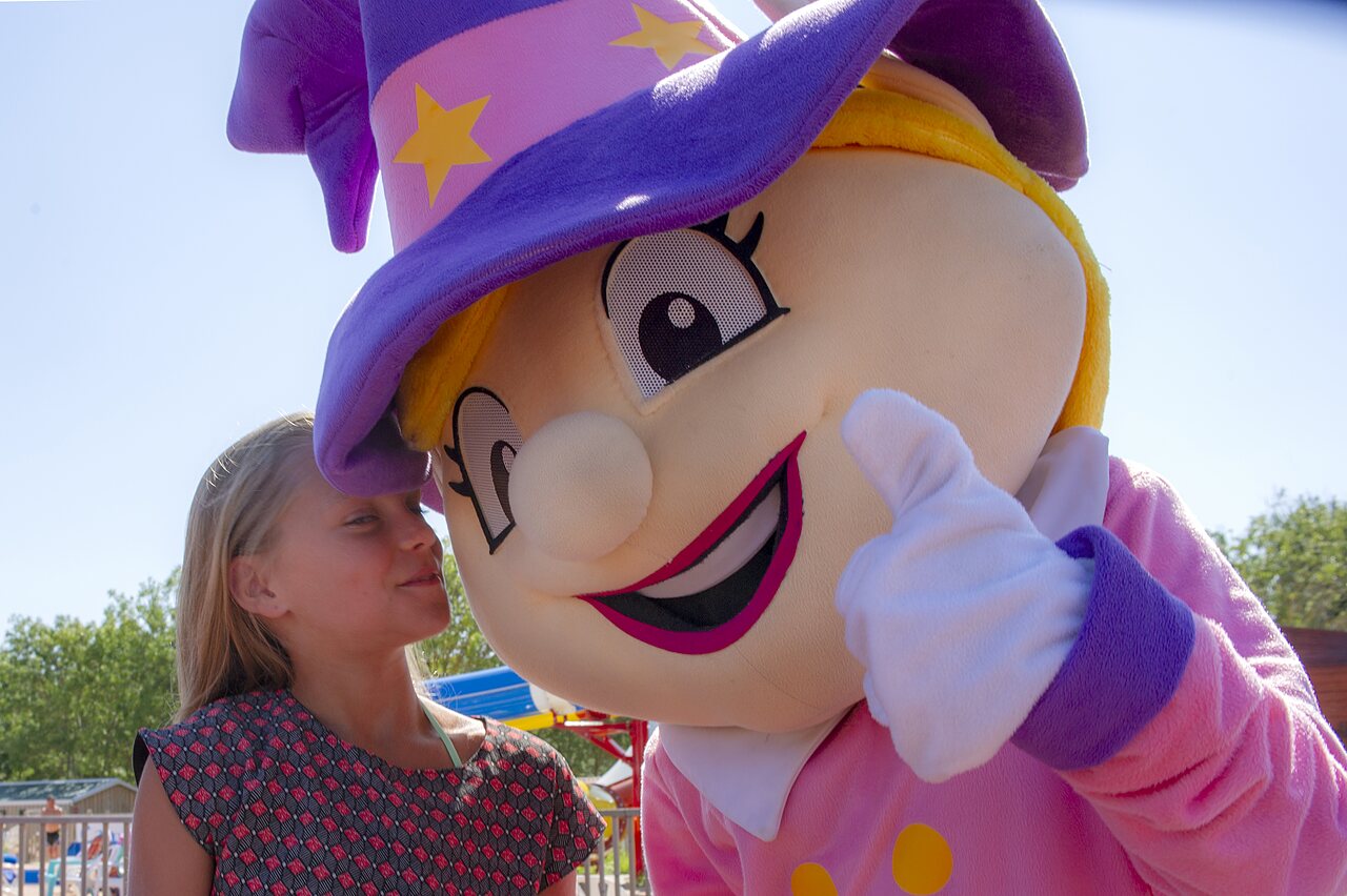 Smiling girl with animation mascot giving a thumbs-up at CAPFUN Europing campsite in Tarquinia (01).