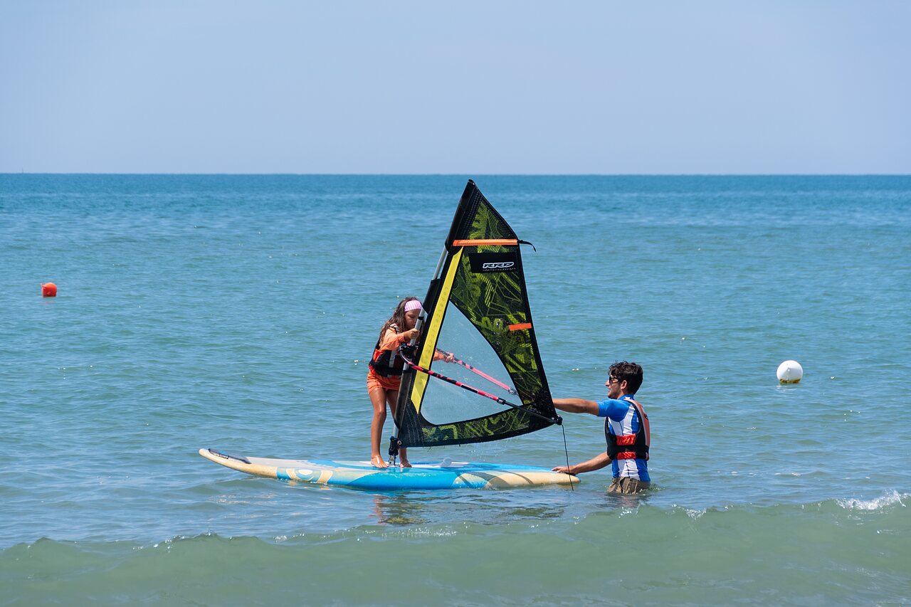 Windsurfing lesson for child with instructor at CAPFUN Europing campsite in Tarquinia (01).