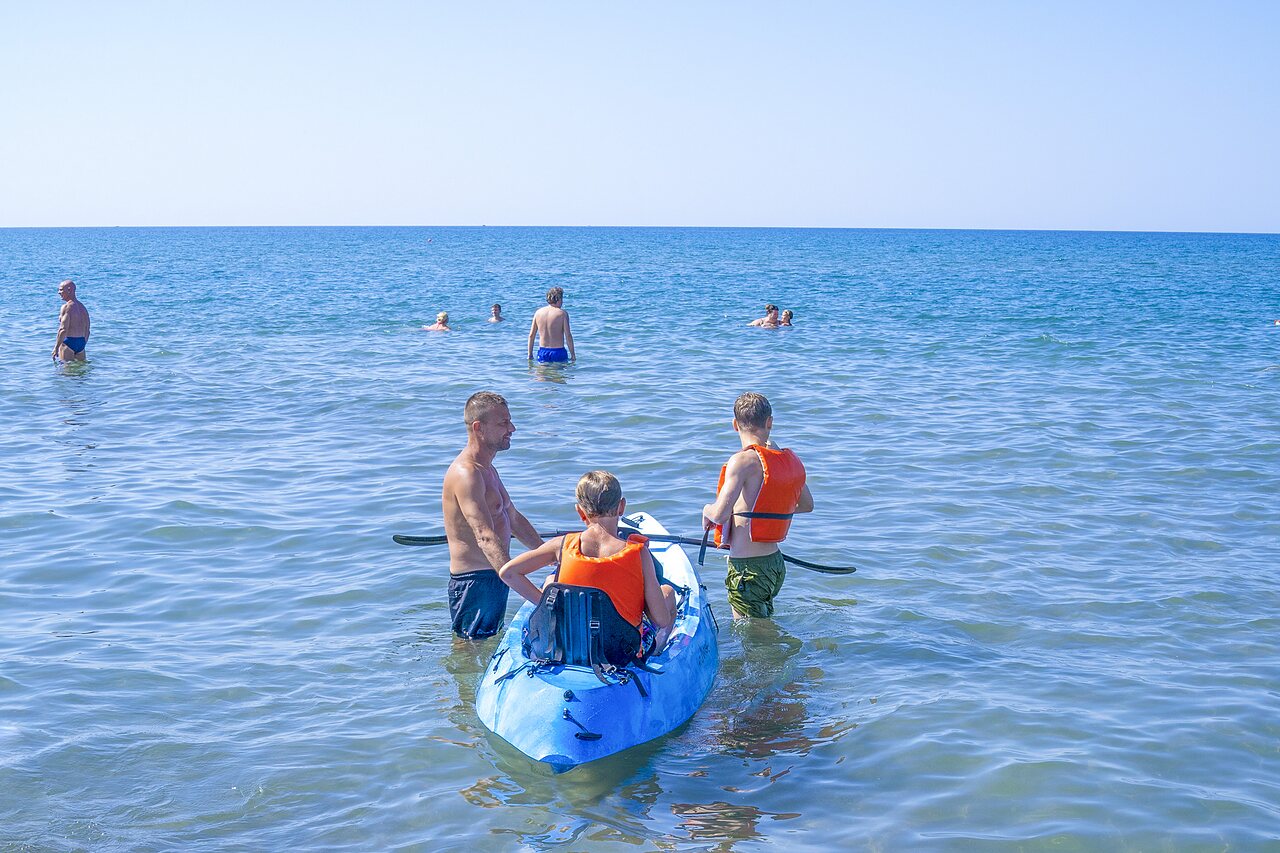Family kayaking on the sea, life jackets at CAPFUN Europing campsite in Tarquinia (01).