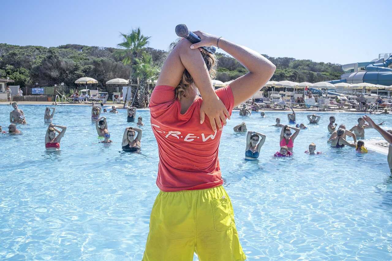 Animator leading an aqua gym session in the swimming pool at CAPFUN Europing campsite in Tarquinia.