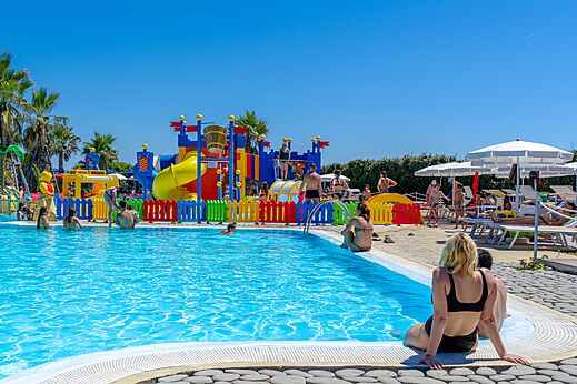 Outdoor swimming pool with slides and water games at CAPFUN Europing campsite in Tarquinia (01).