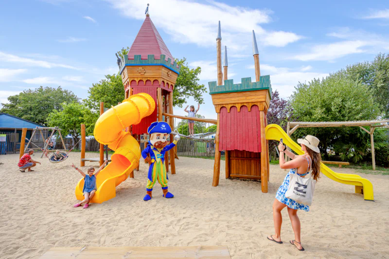 Themed playground with slides, children and mascot at CAPFUN L'Eve campsite in Saint-Marc-sur-Mer (44).