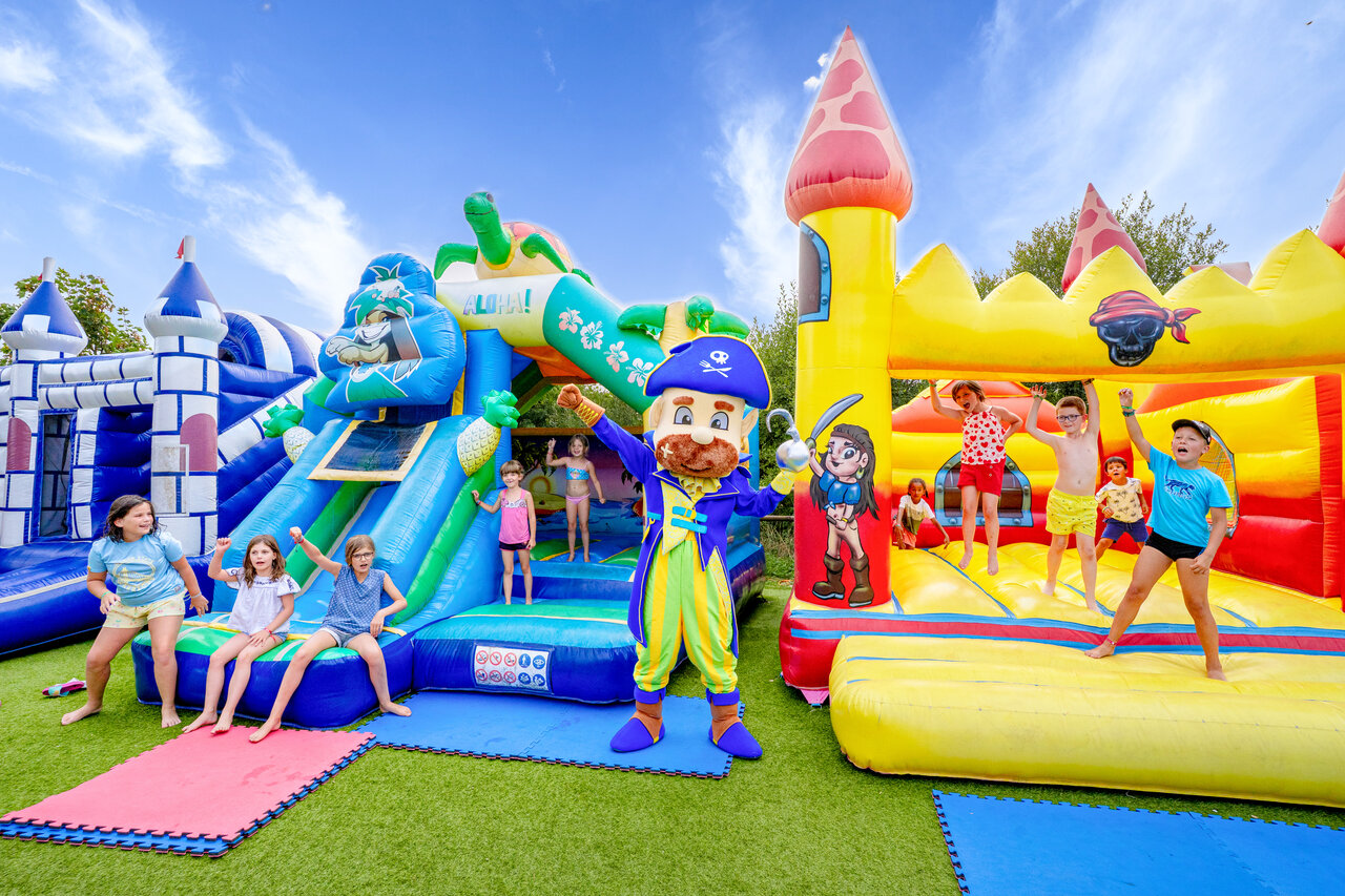 Inflatable games, slides and children with pirate mascot at CAPFUN L'Eve campsite in Saint-Marc-sur-Mer.