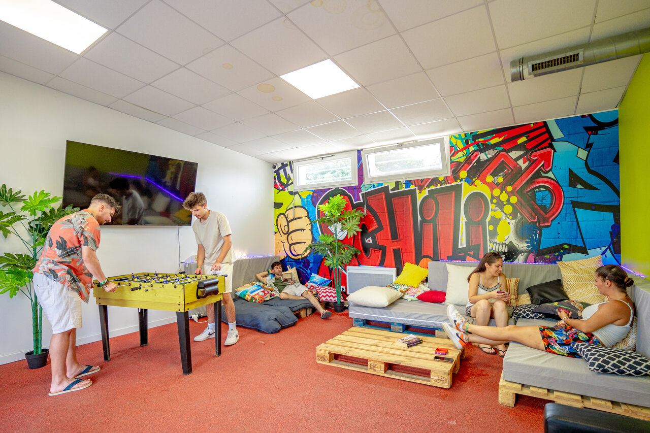 Foosball table and lounge area in games room at CAPFUN L'Eve campsite.