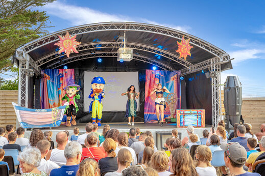 Outdoor stage entertainment show with mascots and performers at CAPFUN L'Eve campsite in Saint-Marc-sur-Mer (44).
