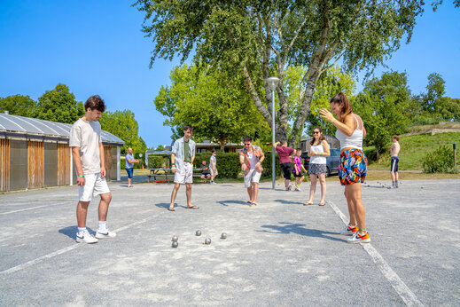 Friendly game of pétanque on the court at CAPFUN L'Eve campsite.