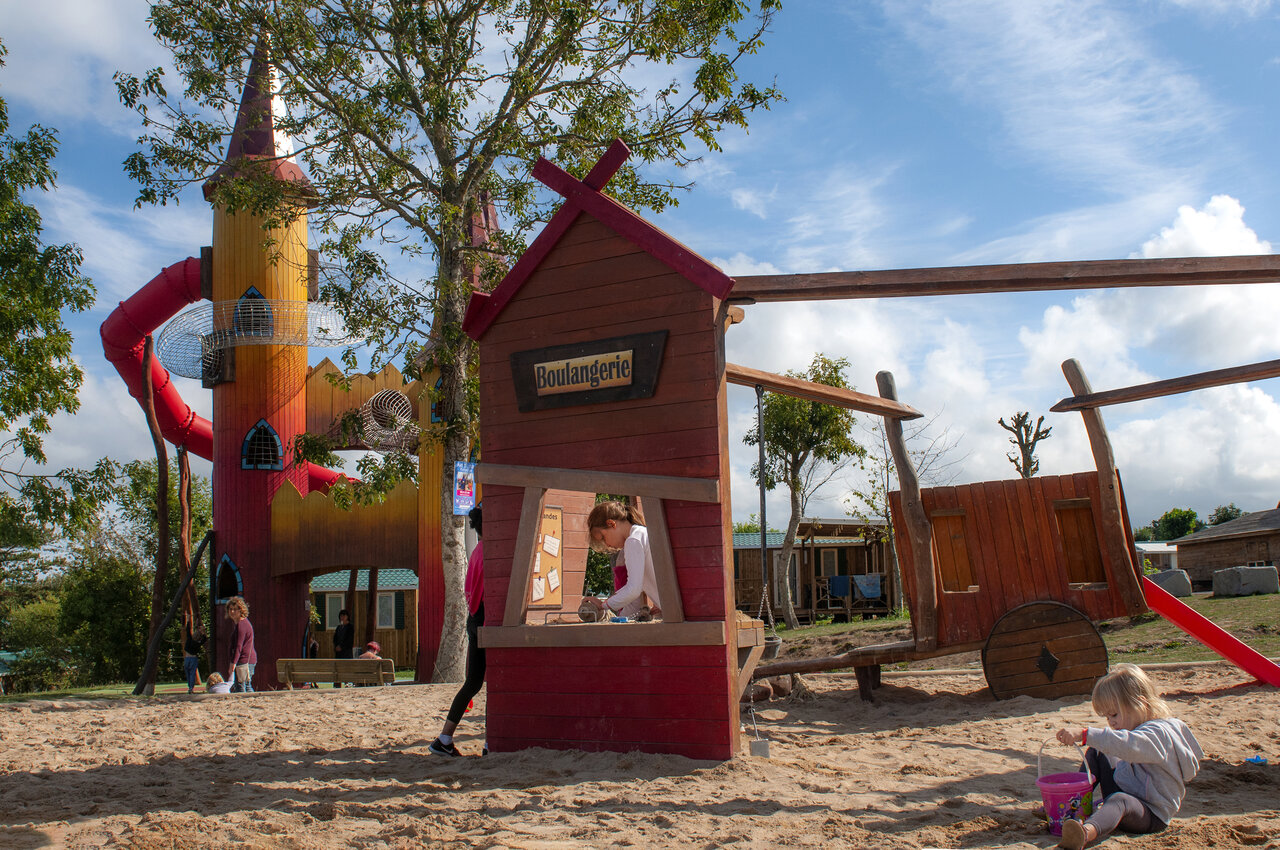 Playground with castle, slide, and bakery at CAPFUN Falaises campsite in Gonneville sur Mer (14).