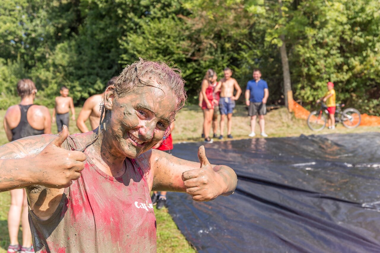 Smiling youth covered in mud after an animation activity at CAPFUN Falaises campsite in Gonneville sur Mer (14).