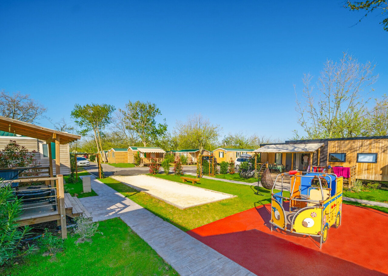 Colorful playground, p�tanque court and mobile homes at CAPFUN F�erix campsite in MARSEILLAN PLAGE (34).