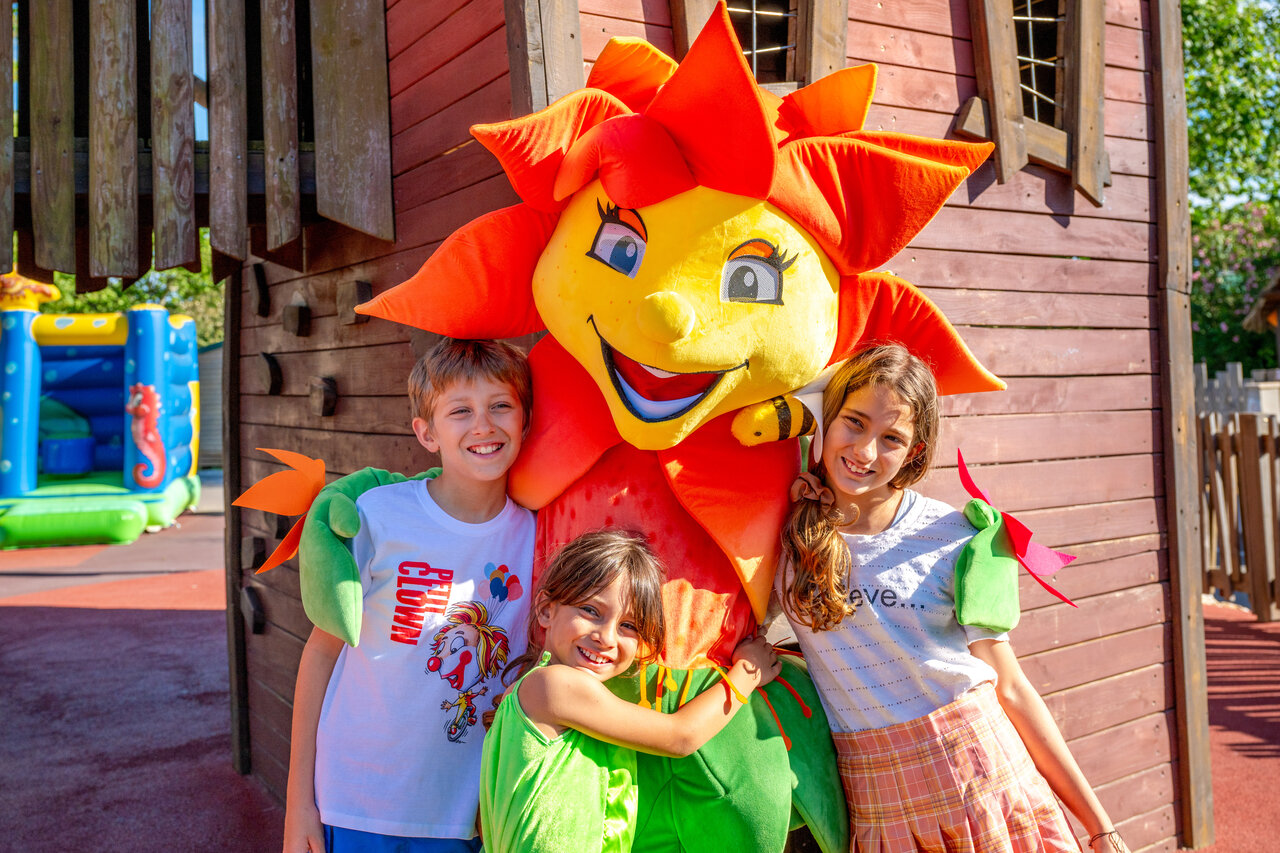 Smiling children with mascot and bouncy castle at CAPFUN F�erix campsite in MARSEILLAN PLAGE (34).