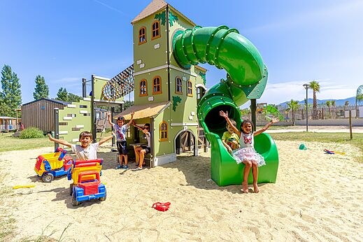 Playground with slide and happy children at VAGUES OCEANES Au Flamenco campsite in Argel�s-sur-Mer (66).