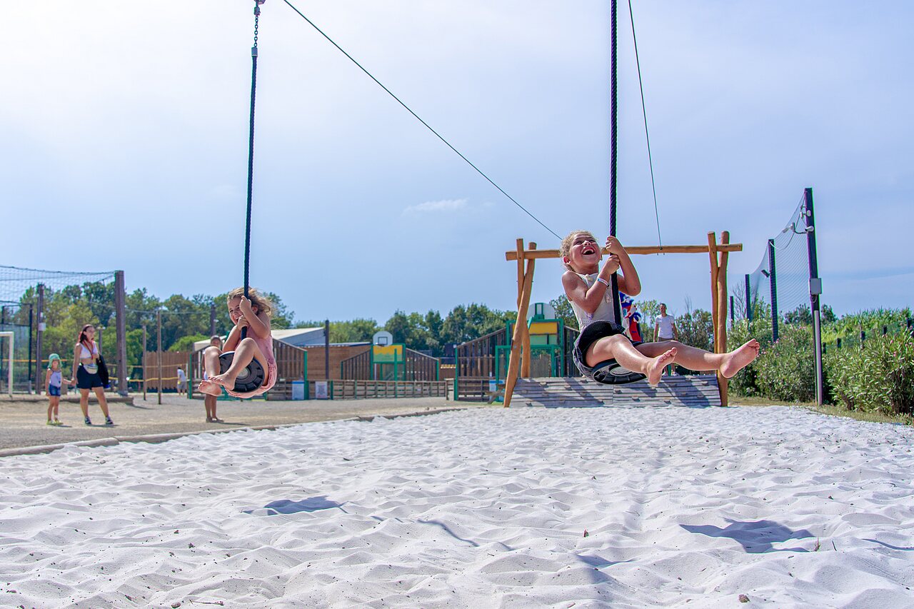 Happy children on zip lines over sand at CAPFUN Fleurs d'Agde campsite in AGDE (34).