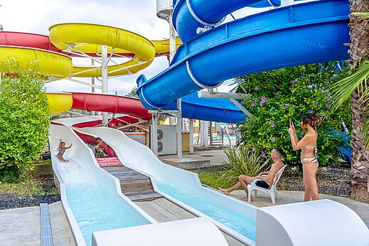 Colorful water slides and child sliding at CAPFUN Fleurs d'Agde campsite in AGDE (34).