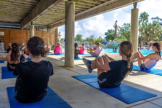 Group fitness class under cover near the swimming pool at CAPFUN Fleurs d'Agde campsite in AGDE (34).