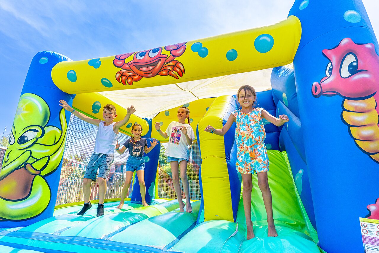 Children having fun on bouncy castle at CAPFUN Flots Bleus campsite in VIAS PLAGE (34).