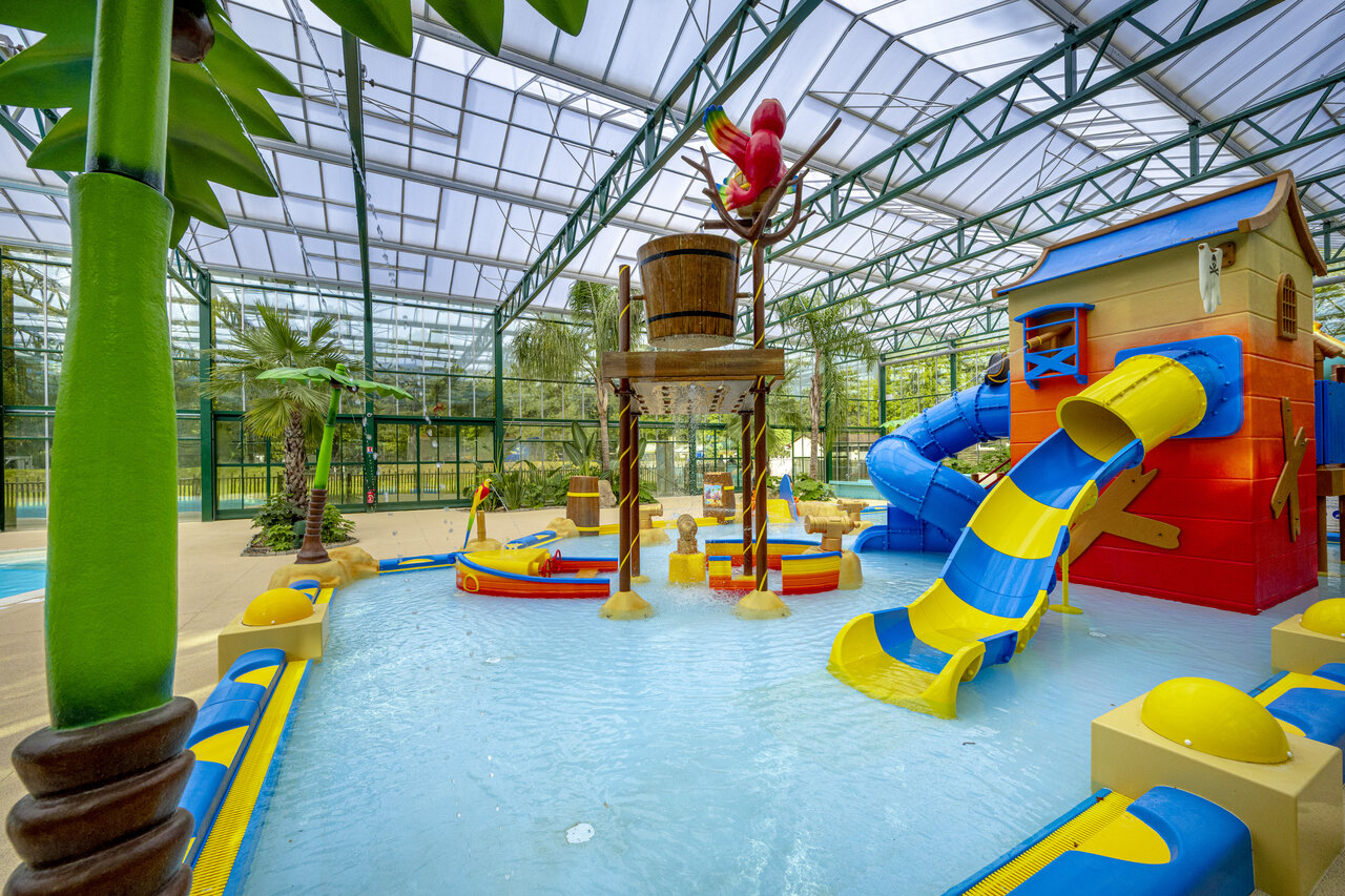 Indoor pool, water slides, tipping bucket and kids' play area at camping CLICOCHIC La For�t d'Azal�e in Saint-Ch�ron (91).