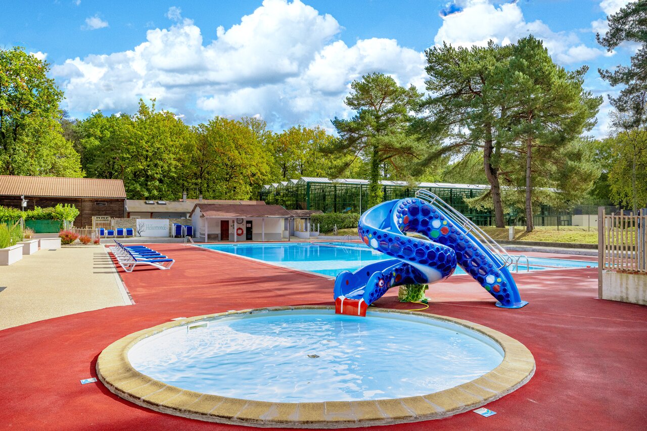 Outdoor swimming pool with water slide and paddling pool at CLICOCHIC La For�t d'Azal�e campsite in Saint-Ch�ron (91).