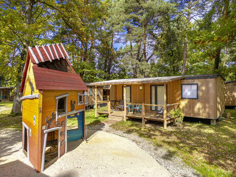 Children's playground and wooden Mobile homes at camping CLICOCHIC La Forêt d'Azalée (91).
