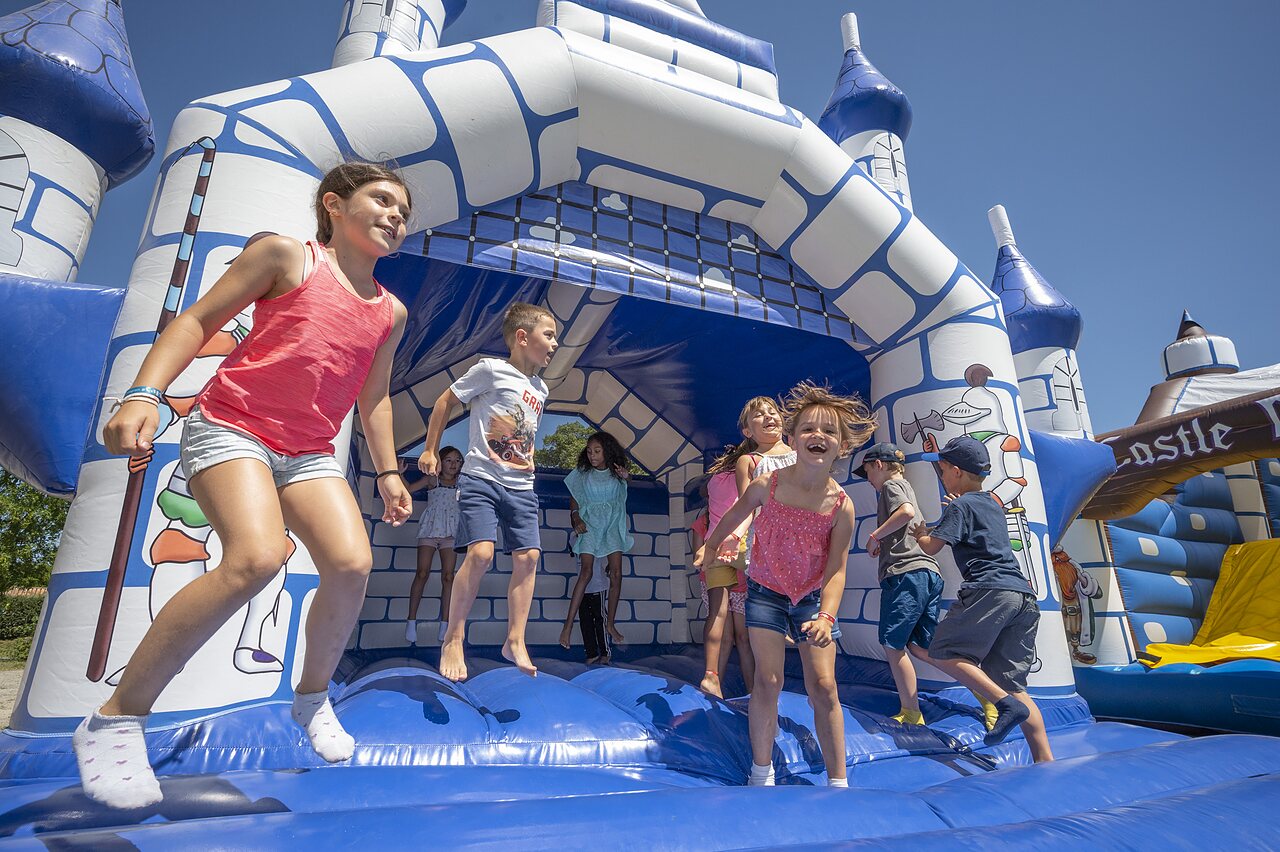 Giant bouncy castle with smiling children at CAPFUN Forges campsite in Avrille (85).