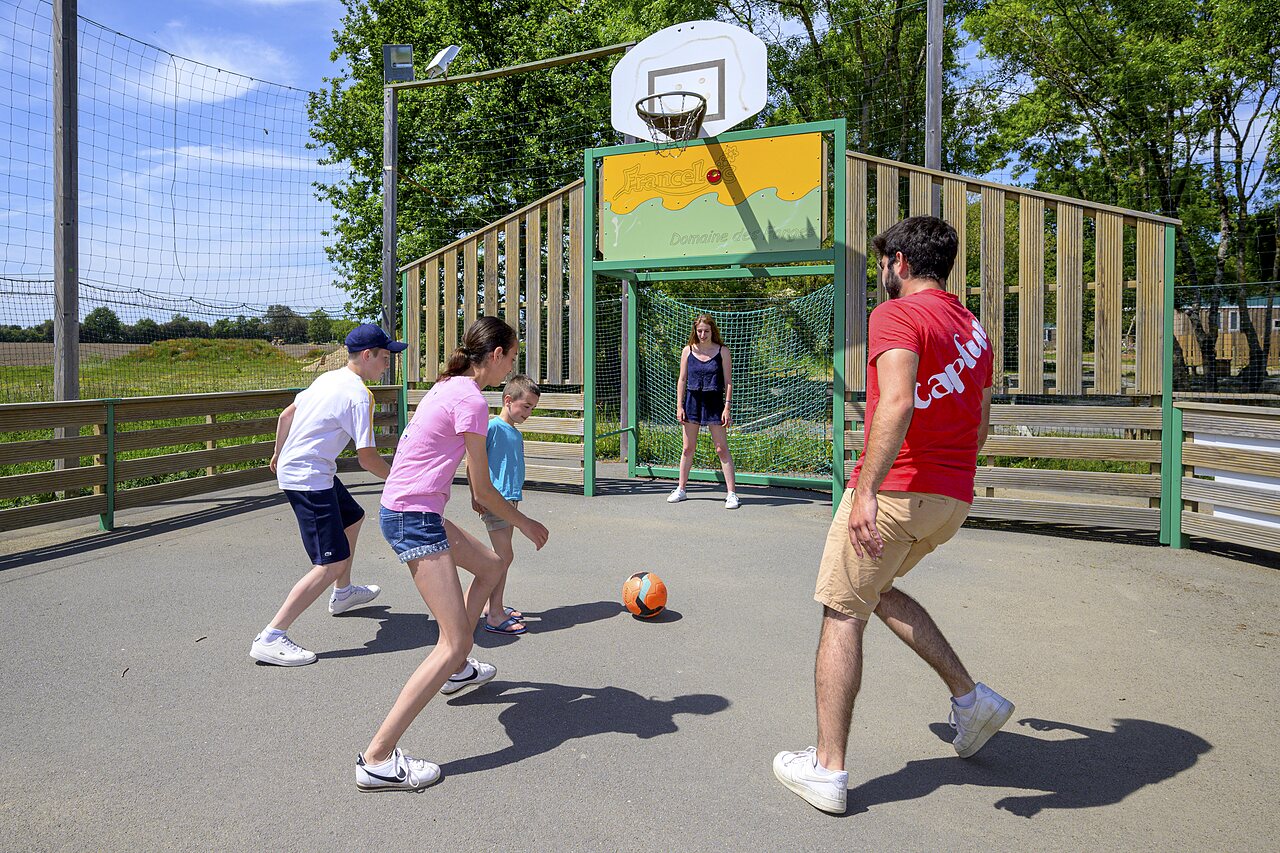 Family playing football on multi-sport court CAPFUN Forges in Avrille (85).