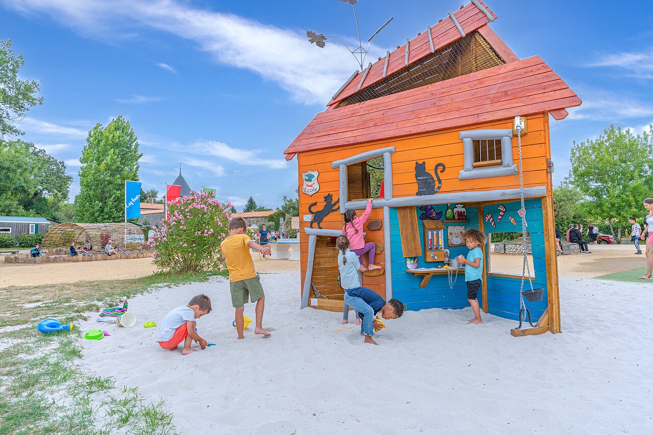 Playground with large wooden structure and sandpit at CAPFUN Forges campsite in Avrille (85).