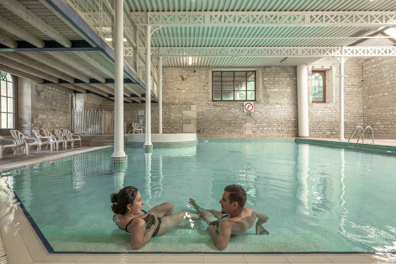 Heated indoor swimming pool, couple, at CLICOCHIC Forge Sainte Marie campsite in Thonnance-les-Moulins (52).