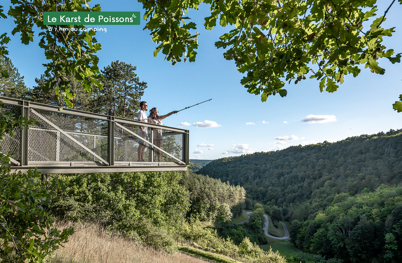 Karst de Poissons viewpoint, couple admiring forested valley, Haute-Marne region.