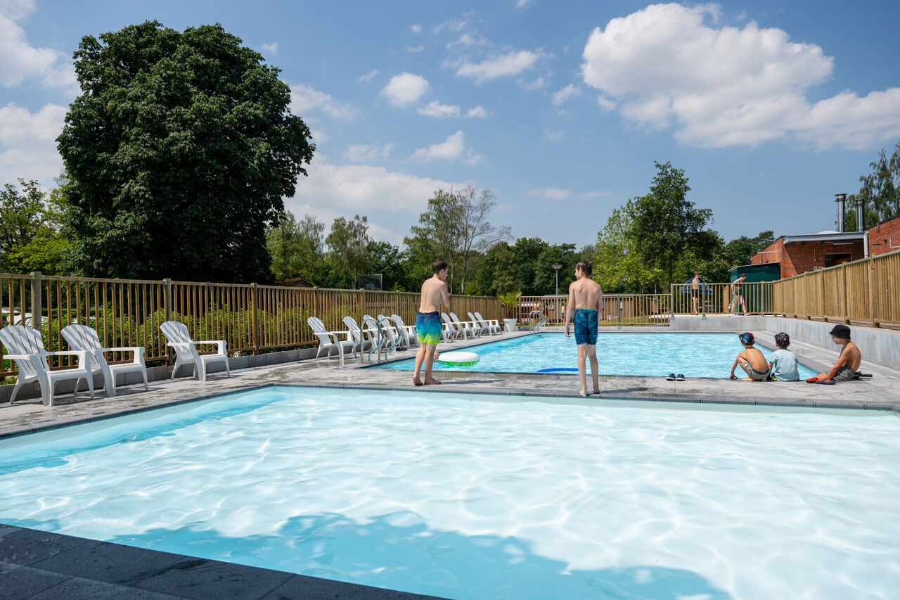 Outdoor pool, children and lounge chairs at CAPFUN Fort Bedmar campsite in Sint-Gillis-Waas.