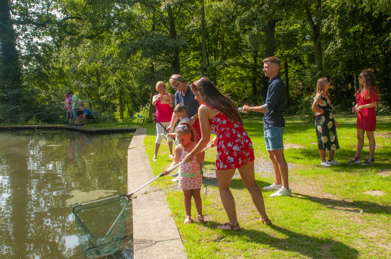 Family fishing by the pond at CAPFUN Fort Bedmar campsite in Sint-Gillis-Waas.