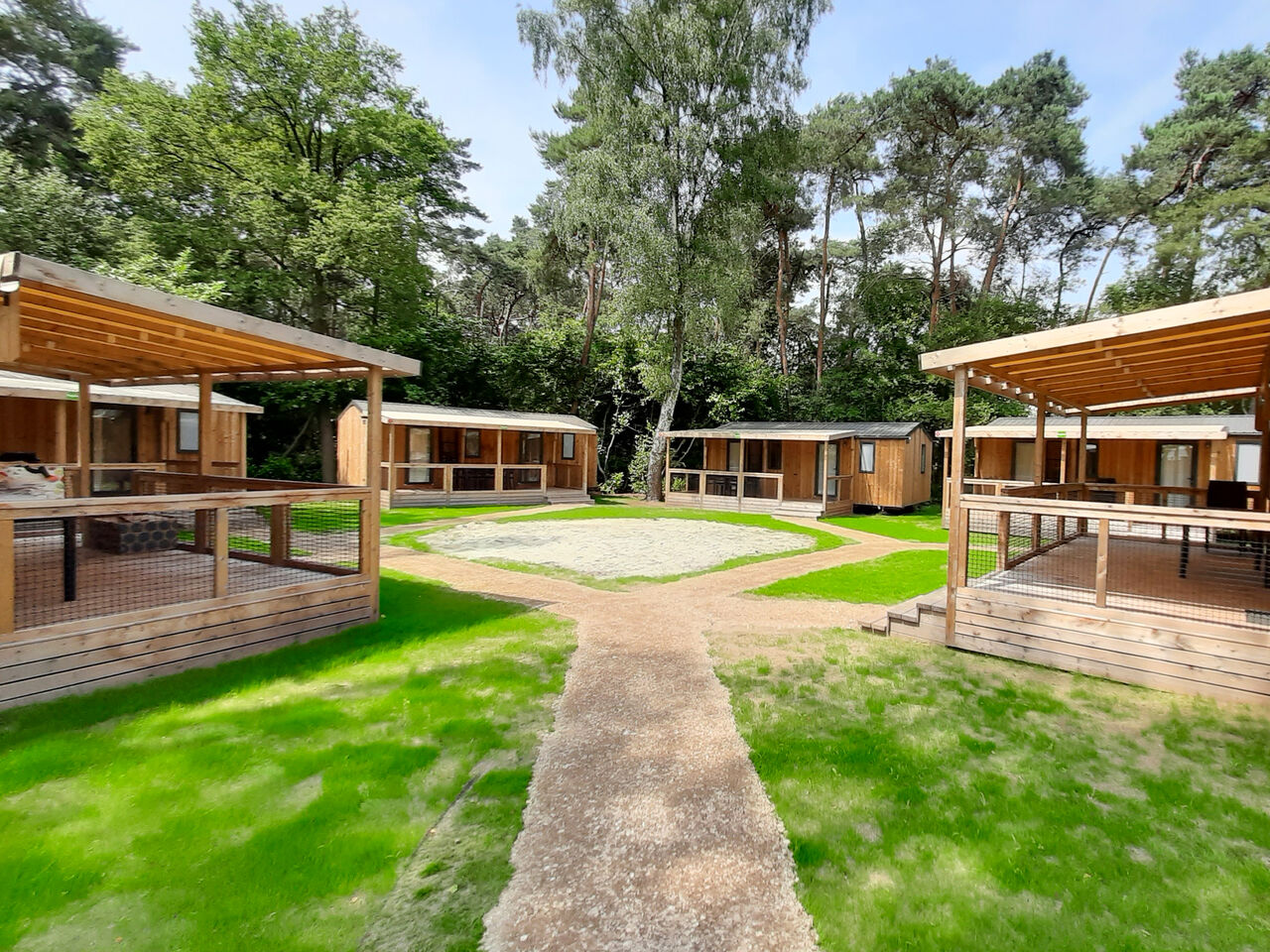 Modern wooden chalets with covered terraces at CAPFUN Fort Bedmar campsite in Sint-Gillis-Waas.