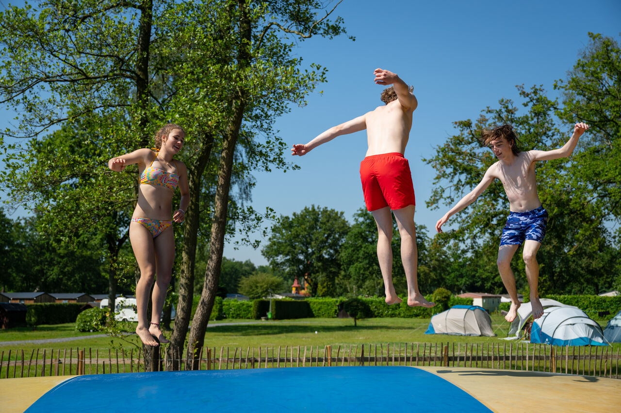 Teenagers jump on bouncy pillow at CAPFUN Fort Bedmar campsite in Sint-Gillis-Waas.