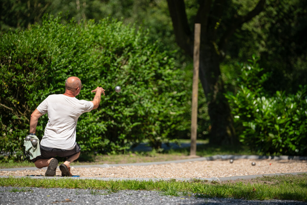Man playing p�tanque on a boules court at CAPFUN Fort Bedmar campsite in Sint-Gillis-Waas.