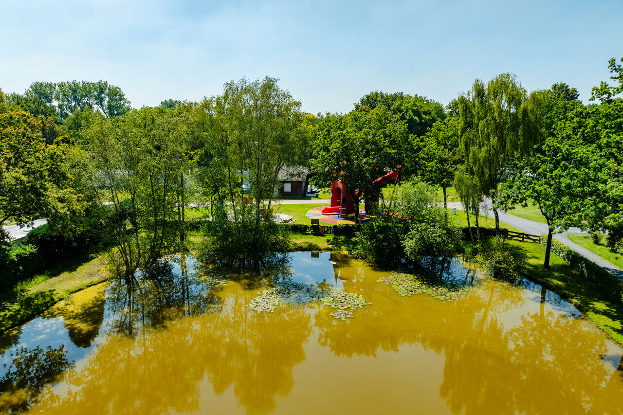 Aerial view pond, trees, children's play area at CAPFUN Fort Bedmar campsite in Sint-Gillis-Waas.