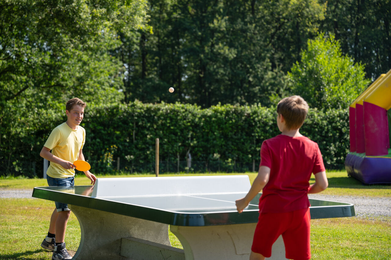Two boys playing outdoor table tennis at CAPFUN Fort Bedmar campsite in Sint-Gillis-Waas.