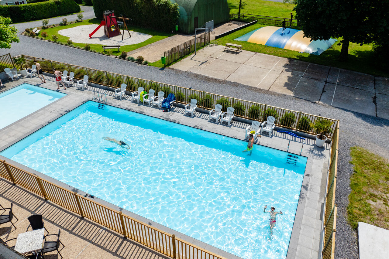 Outdoor swimming pool, playground and bouncy castle at CAPFUN Fort Bedmar campsite.