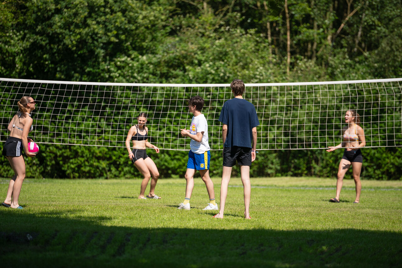Young people playing volleyball on outdoor court at CAPFUN Fort Bedmar campsite in Sint-Gillis-Waas.