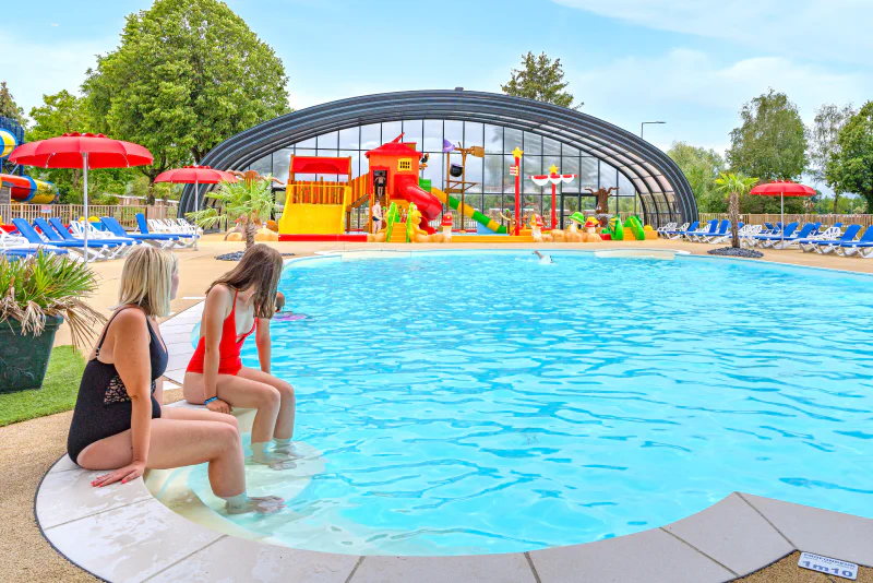 Two women by the pool with water games at CAPFUN Fort Falabraque campsite in Seltz (67).
