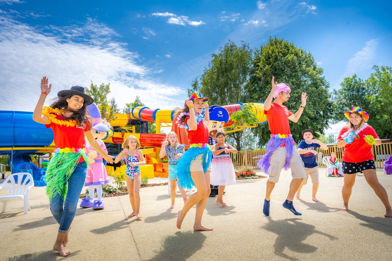 Animators and children happily dancing near water slides at CAPFUN Fort Falabraque campsite in Seltz (67).