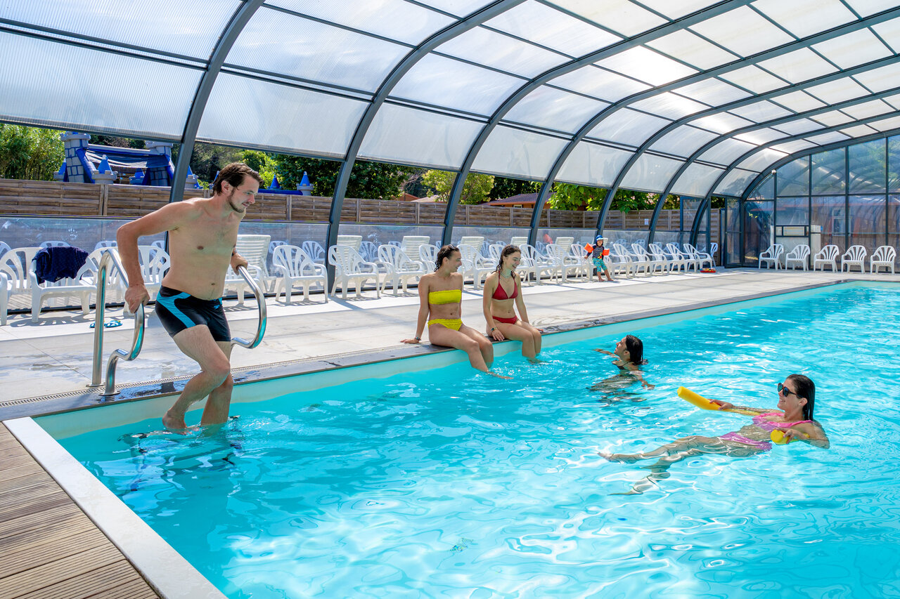 Covered swimming pool, bathers and sun loungers at CAPFUN Le Fr�jus, Fr�jus (83).