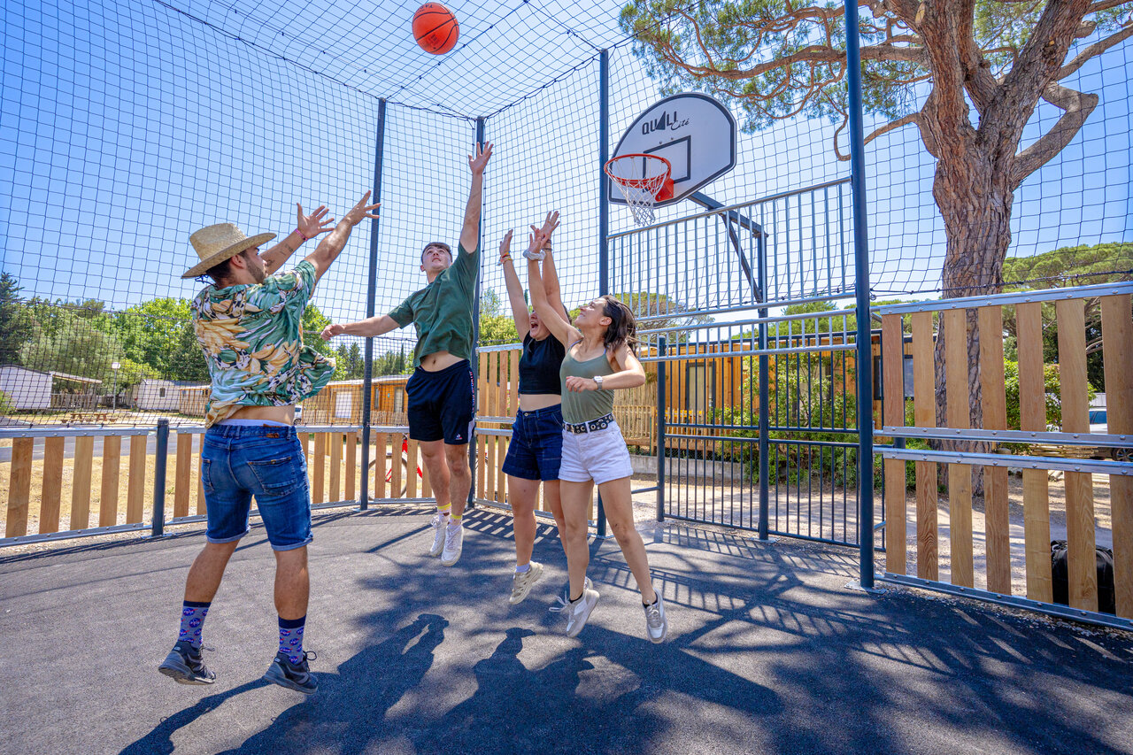 Young people playing basketball on multisport court at CAPFUN Le Fr�jus campsite in Fr�jus.