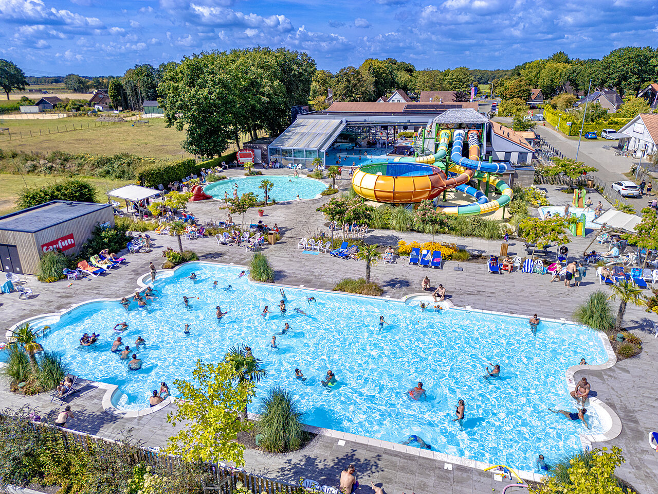 Outdoor swimming pools, water slides and sunbathing area at CAPFUN De Fruithof campsite in Klijndijk.