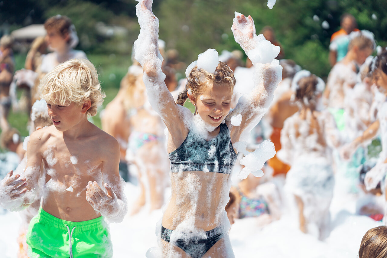 Happy children enjoying a lively foam party at CAPFUN De Fruithof campsite in Klijndijk.