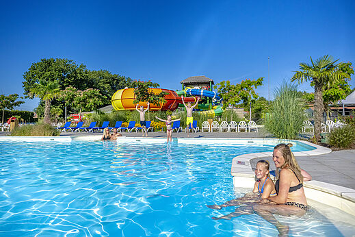 Outdoor swimming pool, colorful water slides at CAPFUN De Fruithof campsite in Klijndijk.