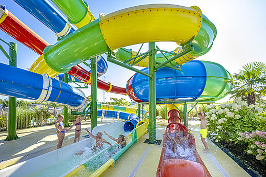 Giant colorful water slides with children at CAPFUN De Fruithof campsite in Klijndijk.