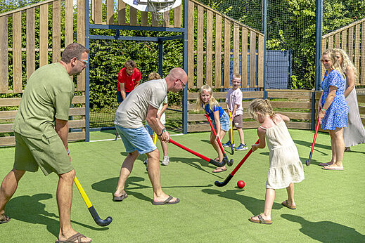 Family playing field hockey at camping CAPFUN De Fruithof in Klijndijk.