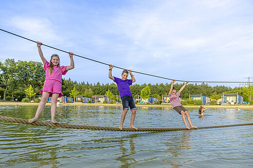 Children enjoying a water obstacle course at CAPFUN De Fruithof campsite in Klijndijk.